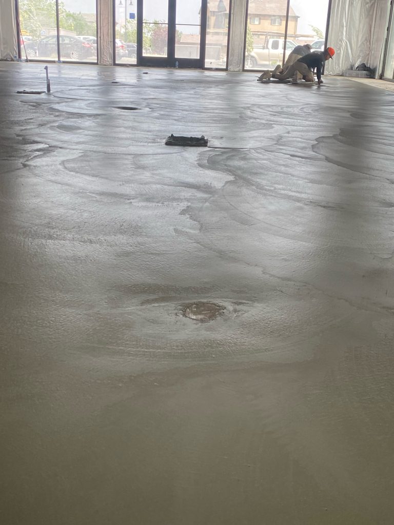 Workers from Black Diamond Builders smoothing the concrete floor during the construction of Don Joaquin Street Tacos restaurant.