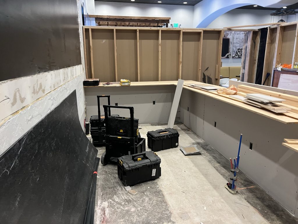 Construction phase of Sol Agave's bar area by Black Diamond Builders, featuring wooden frames and tools.