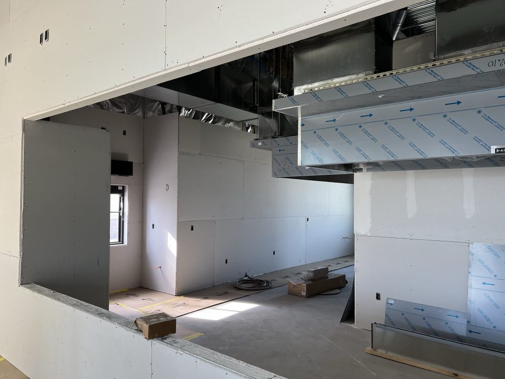 Drywall installation progress by Black Diamond Builders inside Don Joaquin Street Tacos with exposed ductwork and electrical.