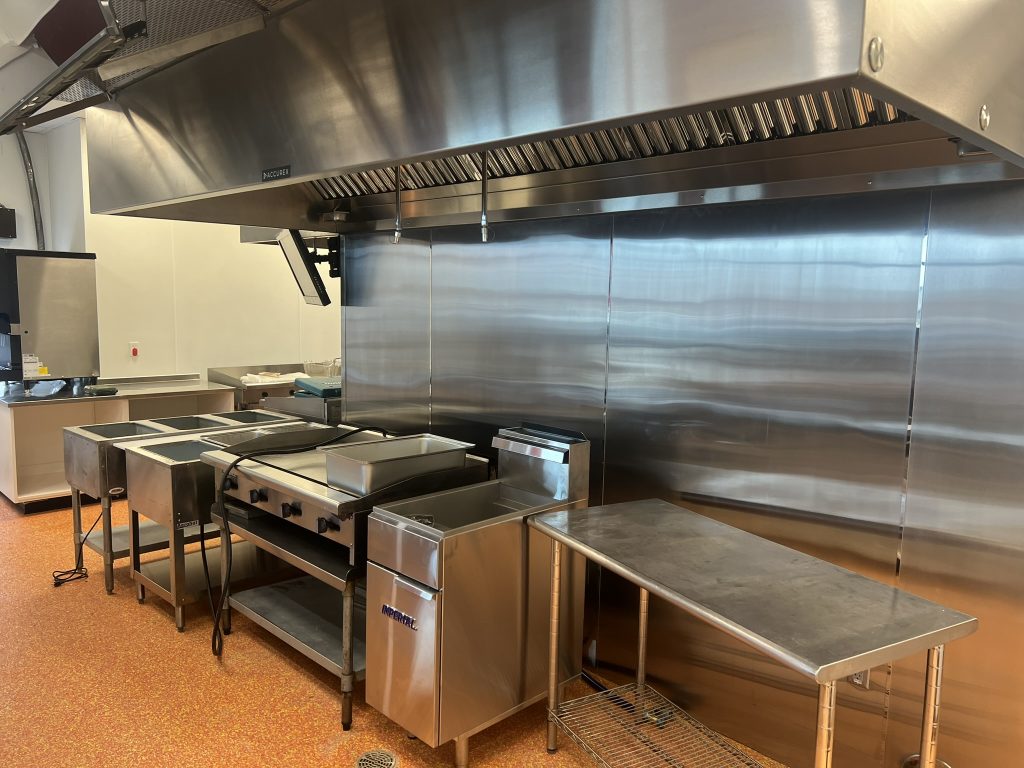 Stainless steel kitchen setup at Don Joquin Street Tacos restaurant, featuring commercial cooking equipment and ventilation.