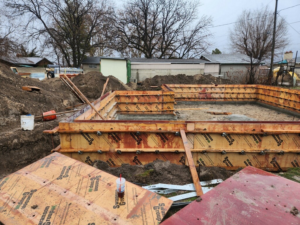Wooden framework set up for the foundation walls of a guest house under construction.